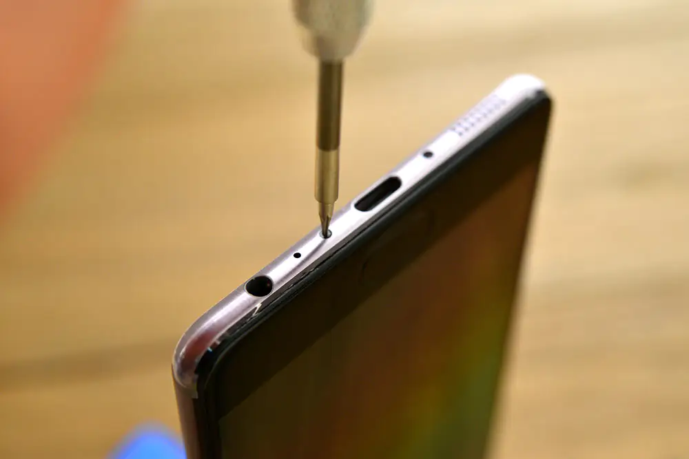 Remove the two screws located on both sides of the USB port